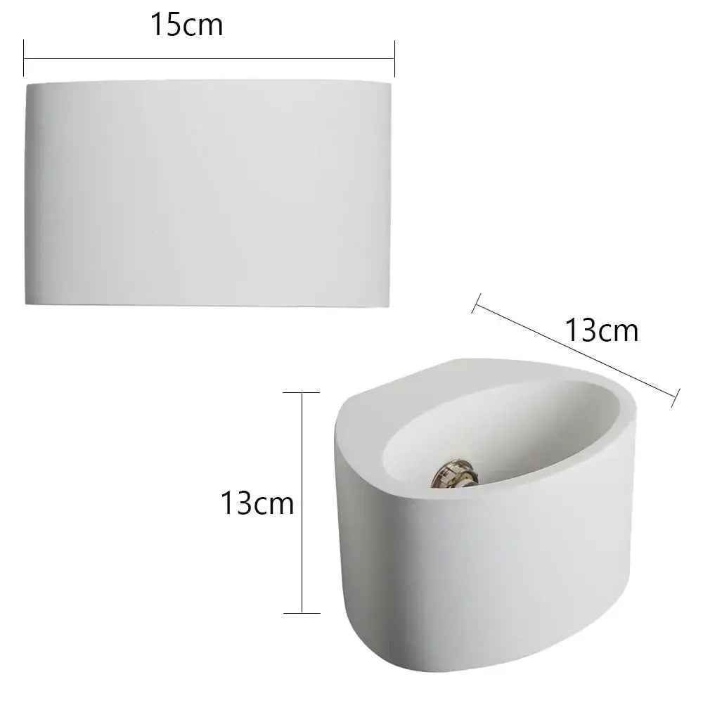White ceramic planter with smooth rounded edges complements modern minimalist white gypsum led wall lamp for bedroom lighting