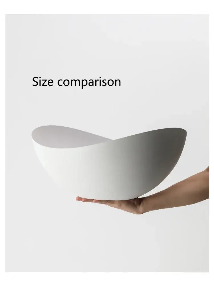A sleek white ceramic bowl with a curved asymmetrical design complementing decorbites ingot ceiling lamp decor