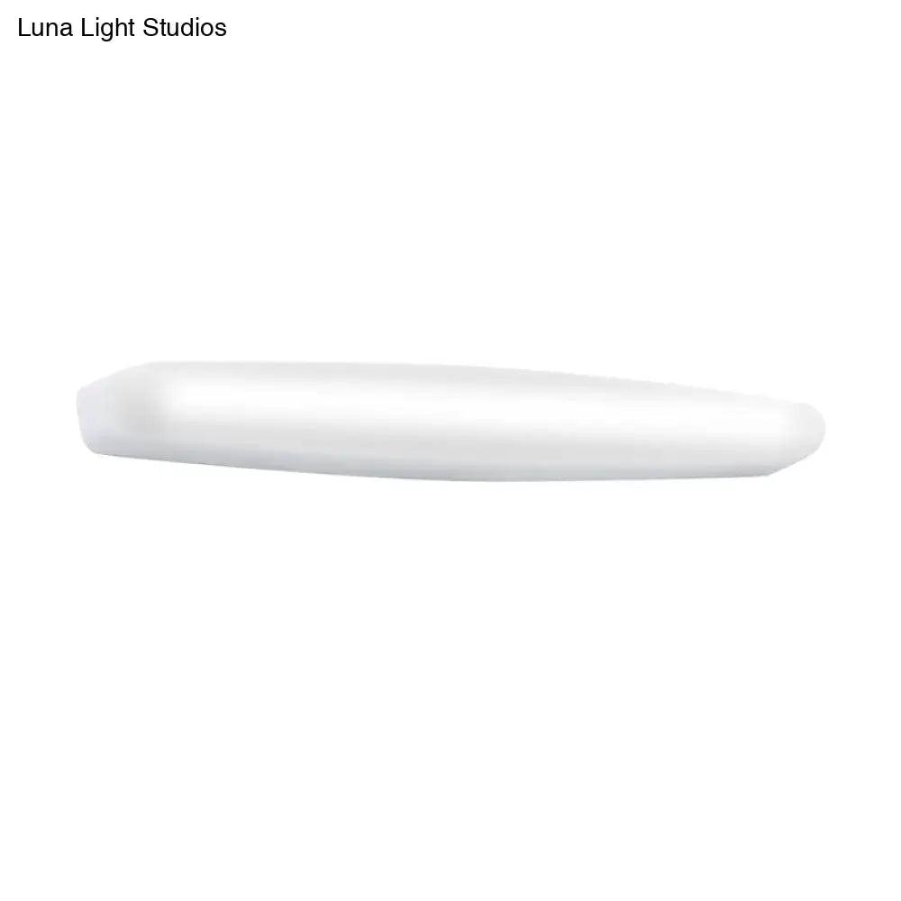 A sleek minimalist white led wall light with a rounded rectangular profile emitting warm white light for bedroom use