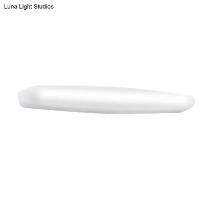 A sleek minimalist white led wall light with a rounded rectangular profile emitting warm white light for bedroom use