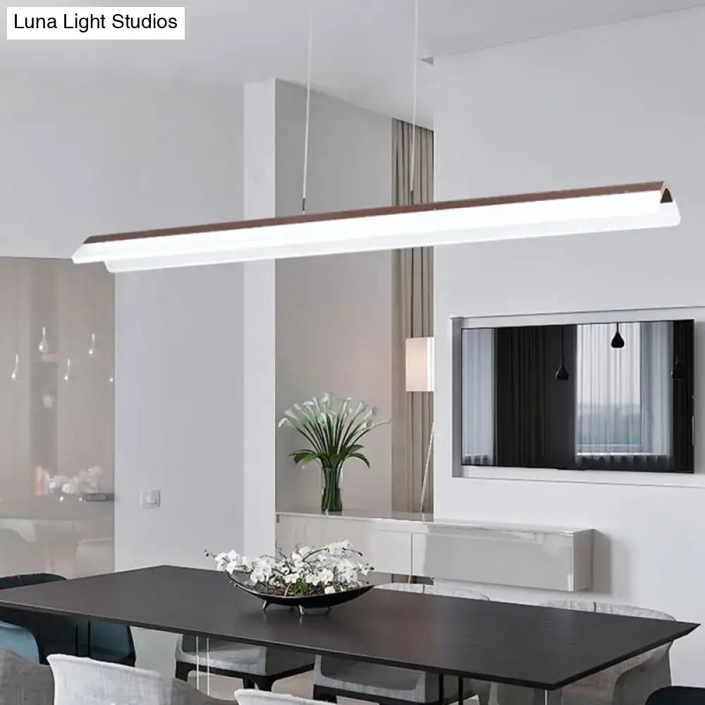 Modern minimalist pendant light fixture with white aluminum body and wood-toned top edge for dining room use