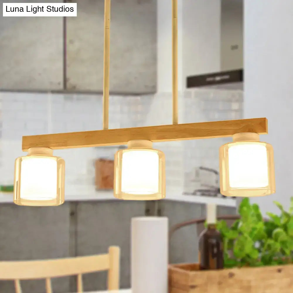 Modern minimalist wood and white glass pendant light with warm brass finish and three heads for dining room illumination