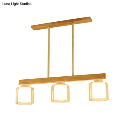 Modern minimalist wood and white glass pendant light with warm wooden frame and three square heads for dining room