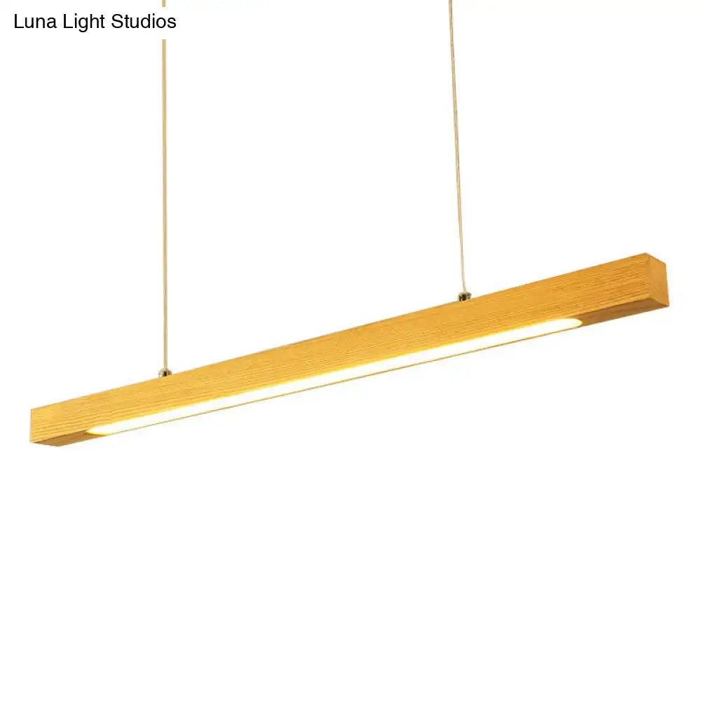 A sleek rectangular wooden pendant light with warm glow and minimalist design for modern linear island pendant use