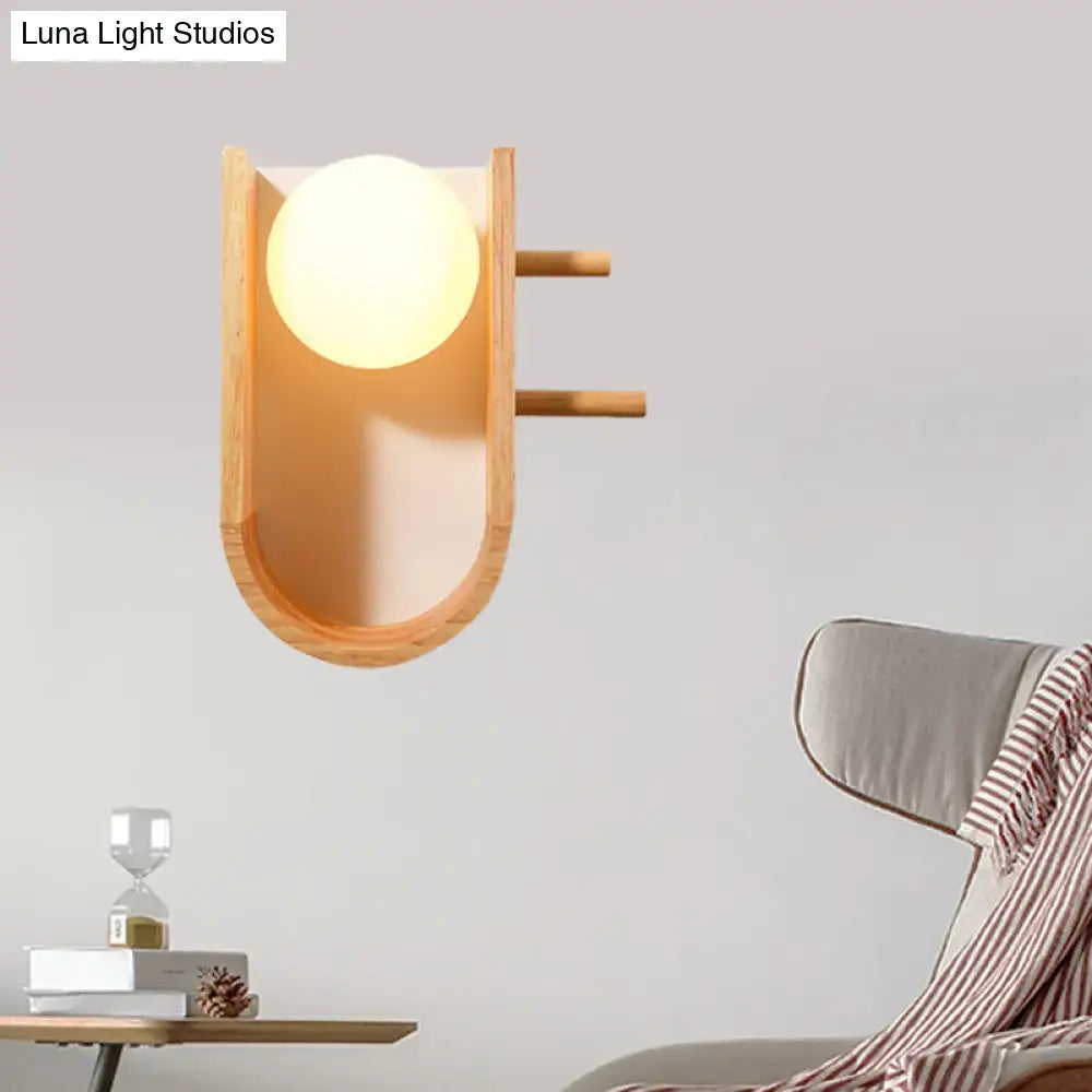 Modern minimalist warm-toned wooden sconce light with a smooth rounded glass globe wall light for bedroom use