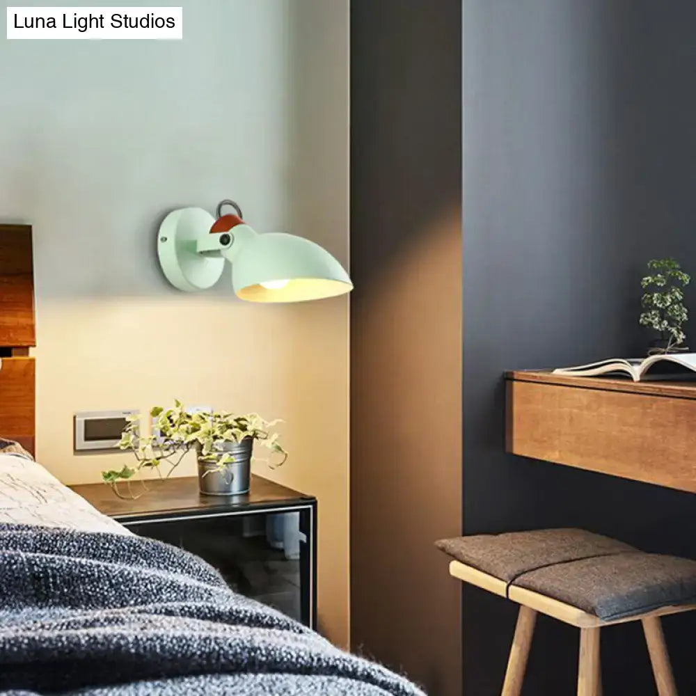 Modern mint green and red wall mounted sconce light with an adjustable arm and rounded shade inch fixture for bedroom use