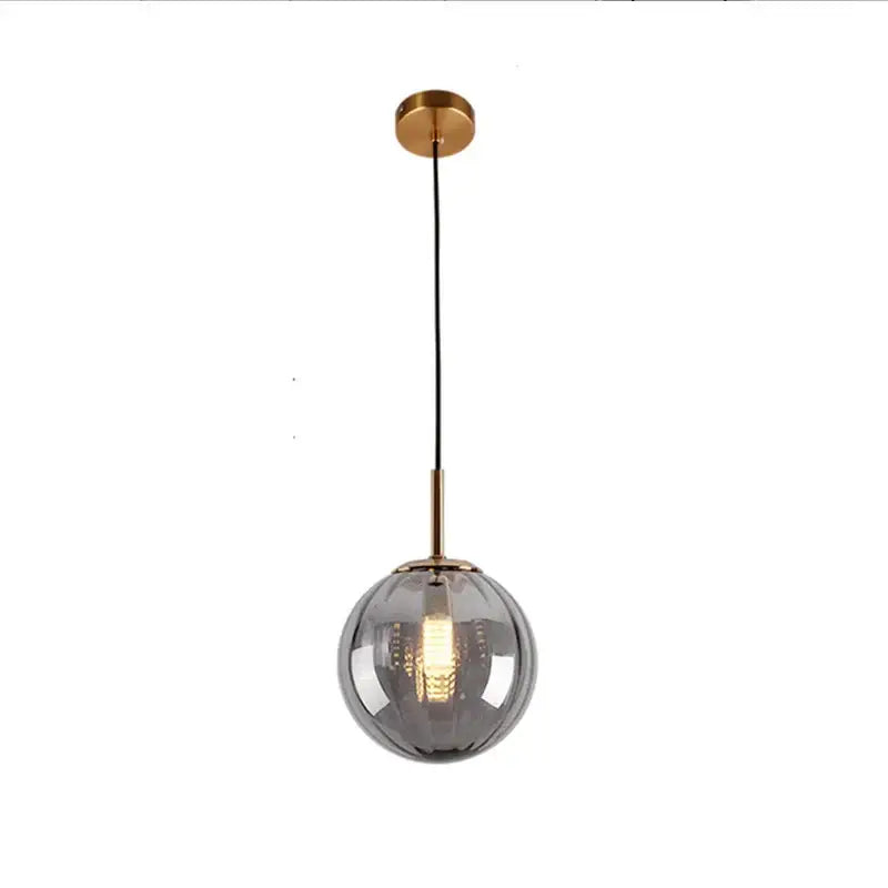 A sleek glass ball pendant lamp with brushed brass finish and black cord from decorbites for modern dining room decor