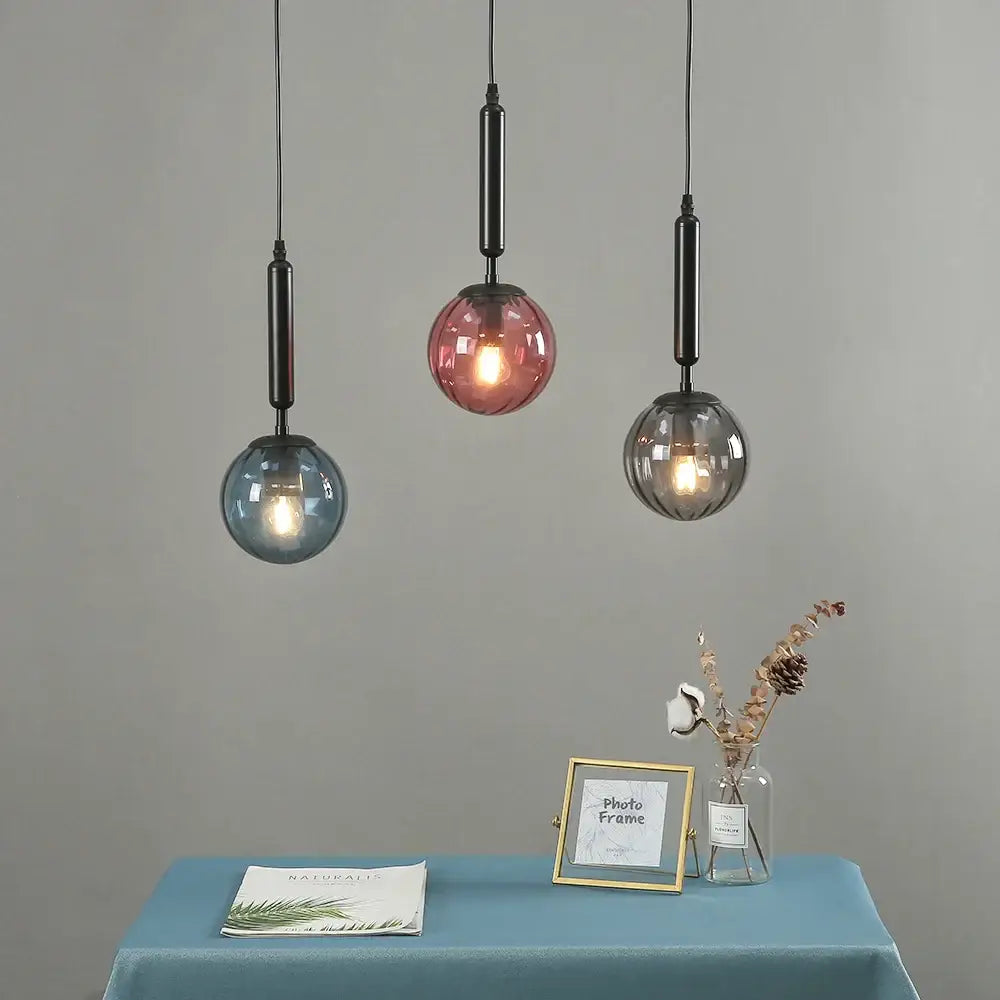 Modern multi color glass pendant light with blue pink gray spherical shades and painted iron rods for dining room