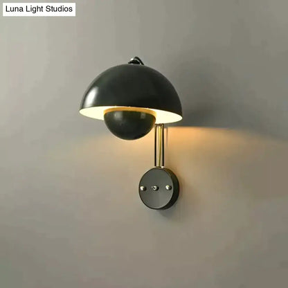 Black matte wall lamp with brass base type and dome-shaped shade in modern mushroom design for bedroom use