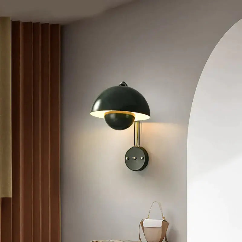 Black matte wall lamp with brass base type and gold-toned stem featuring an elegant dome-shaped shade for bedroom use