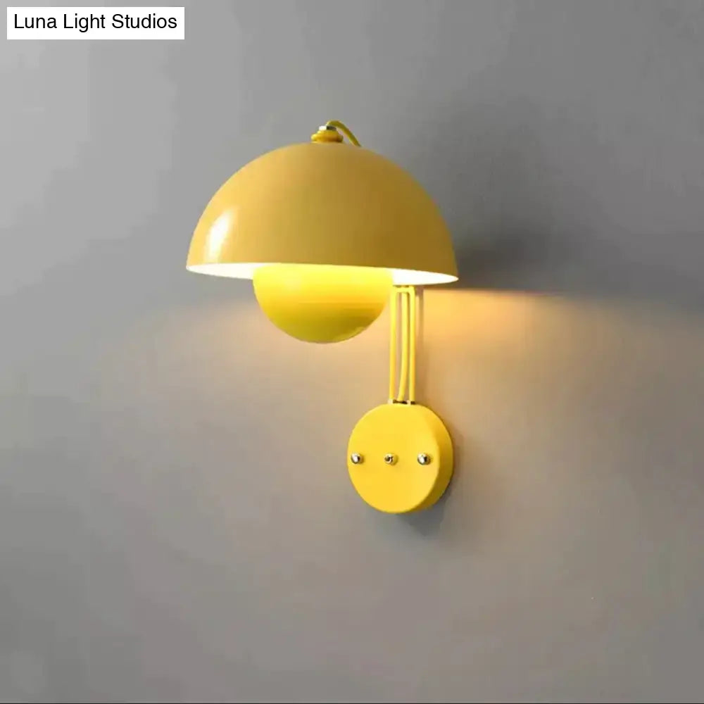 Bright yellow modern wall lamp with dome-shaped shade and brass base type finish for bedroom use