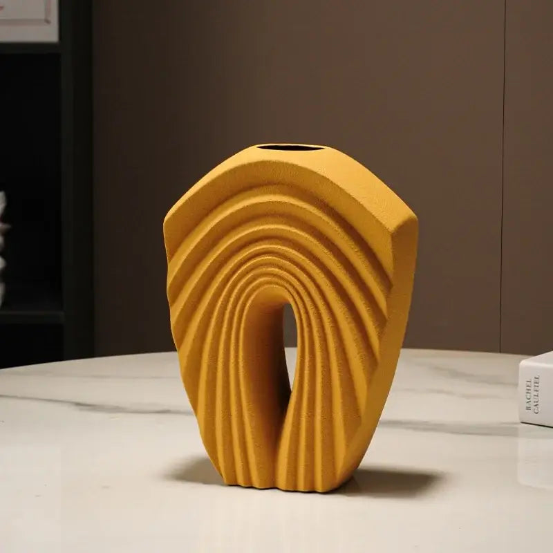 A modern mustard yellow ceramic vase with geometric folds and concentric ridges for stylish living room decor