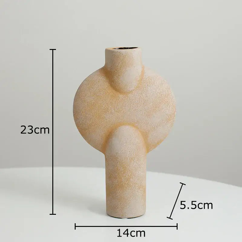 Beige textured decorbites ceramic disc vase with modern abstract shape featuring two rounded protrusions and narrow neck