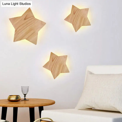 Three lighted wooden star wall lamp sconces with natural finish and visible grain for modern living room decor