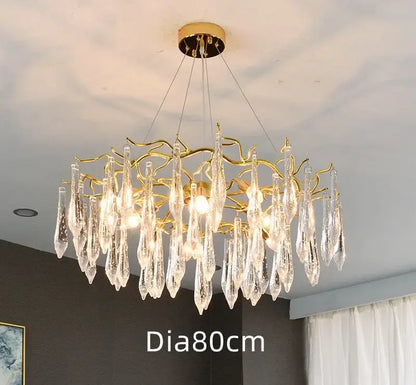 A golden nest crystal led chandelier with a tree-like frame and crystal teardrop pendants for living room lighting