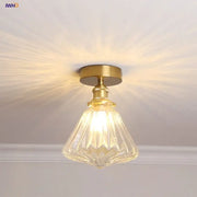 A modern Nordic brass and diamond glass led ceiling light with a clear faceted glass pendant for bedrooms