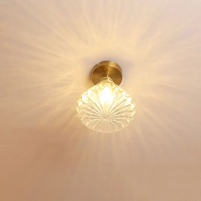 Modern nordic brass and diamond glass led ceiling light with clear faceted shade radiating soft light for bedroom