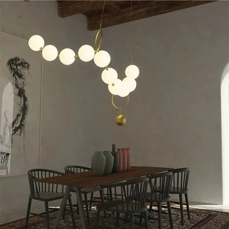 Gold-toned modern nordic led pendant lamp with sculptural rings and orbs for white dining room chandelier decorbites nordic led