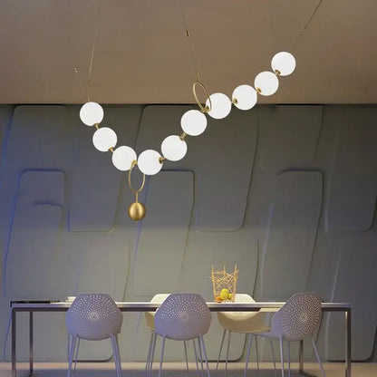 A modern nordic led pendant lamp with white glass globes and gold metal rings ideal for dining room decorbites nordic led