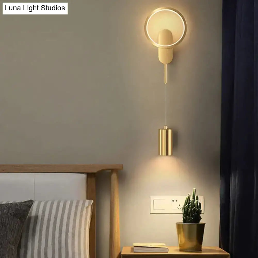 Modern nordic led black gold wall lamp featuring a circular ring and cylindrical pendant emitting warm ambient light