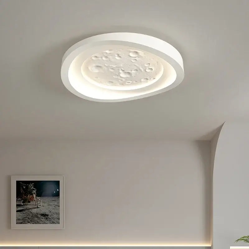 Modern nordic white led ceiling lamp with textured moon surface and raised craters illuminated by soft ambient lighting