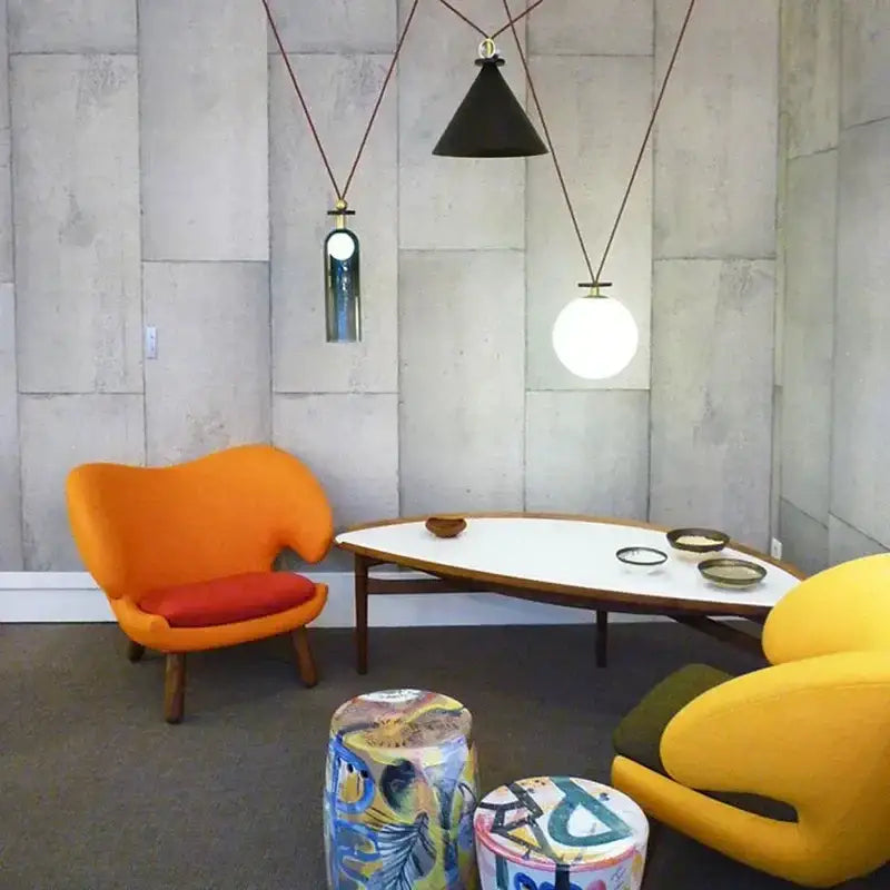 Vibrant orange upholstered armchair with red cushion and wooden legs paired with modern nordic decorbites glass chandelier