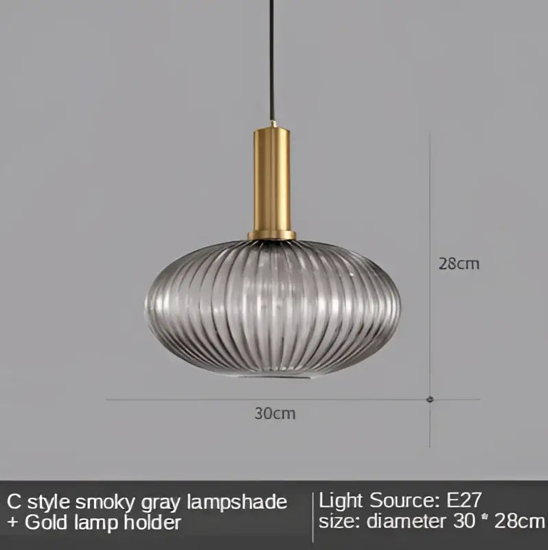 A sleek smoky gray ribbed glass led pendant light with a polished gold metal holder for modern dining rooms