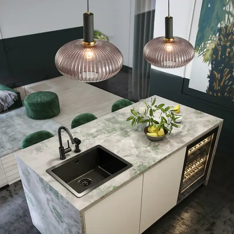 Two modern nordic pendant lights with ribbed translucent rose-gold glass led shades and black fixtures for dining room