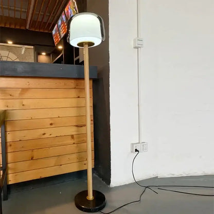Modern nordic wood and glass floor lamp with a sleek white glass shade and slender bamboo pole base for living room