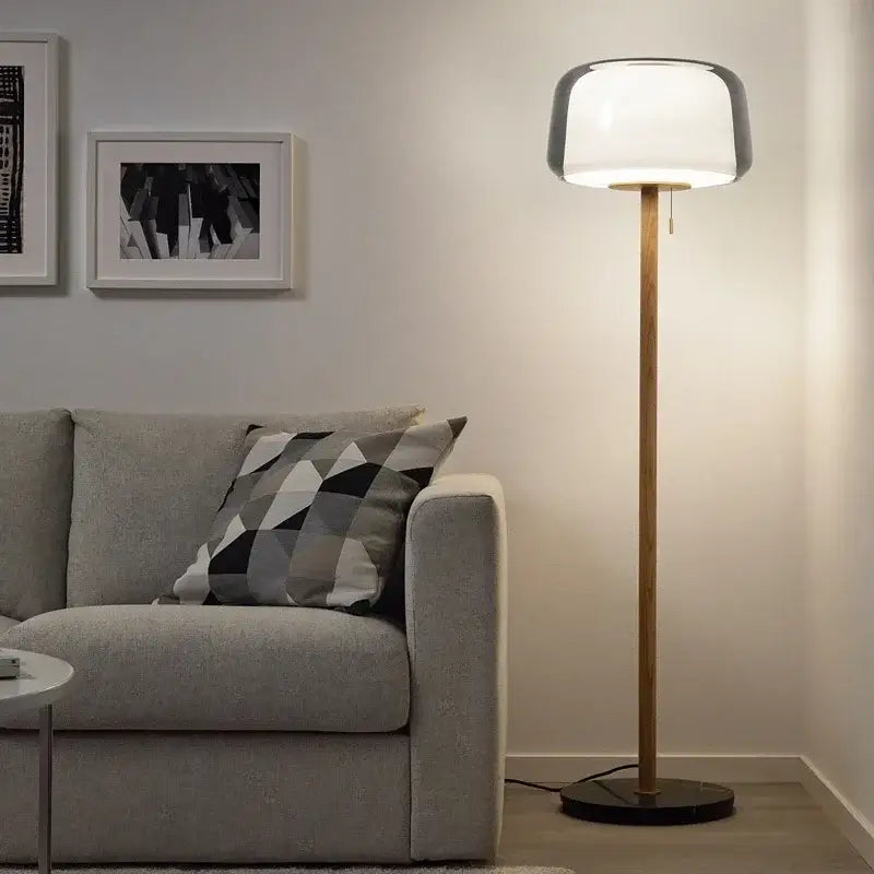 Modern nordic wood and glass floor lamp with a sleek rounded white glass floor shade and slender wooden pole for living room