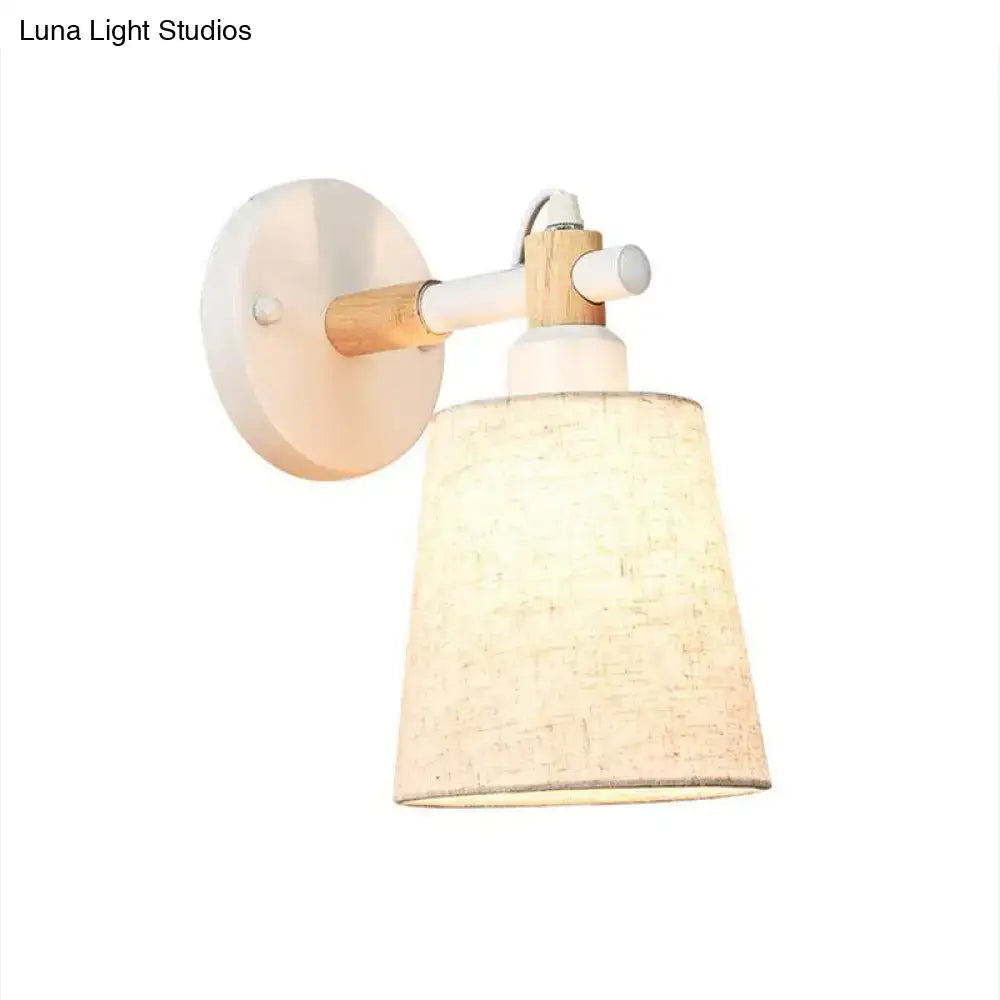 Modern nordic wood wall lamp with white circular base light wood accents and beige horn shade for bedroom sconce