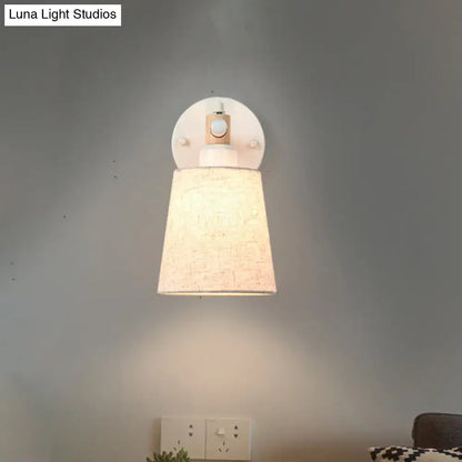 Modern nordic wall lamp with textured beige horn shade, wooden accents, and light bulb, ideal for bedroom use