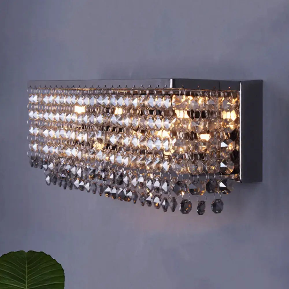 Chrome finish modern octagon crystal wall light with faceted crystal beads cascading in an elegant bedroom sconce design