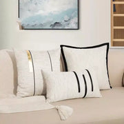 Set of modern off-white cushion covers with decorbites black stripe jaquard and gold accent tassel detail for living room decor
