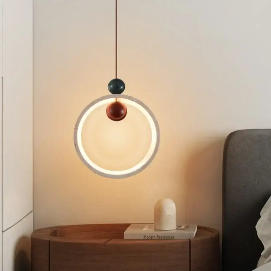 Modern off-white travertine adjustable led pendant light featuring a glowing ring with dark teal and amber beads
