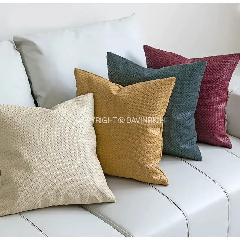 Set of four square pillow covers in beige, mustard, teal, and burgundy with decorbites geometric faux leather texture