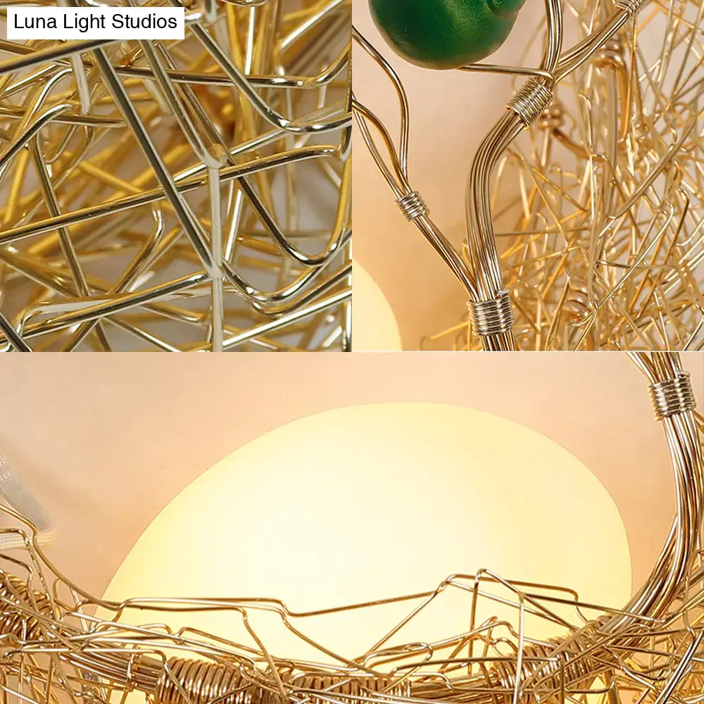 Modern opal glass bird nest sconce light with golden wireframe and warm glowing bulb for living room use
