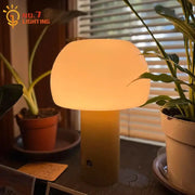 A warm glowing modern orange atmosphere mushroom table lamp with smooth glass shade and matte beige base for decorbites atmosphere mushroom
