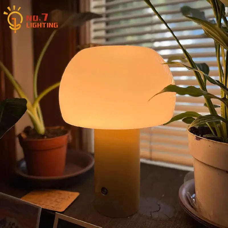 A warm glowing modern orange atmosphere mushroom table lamp with smooth glass shade and matte beige base for decorbites atmosphere mushroom