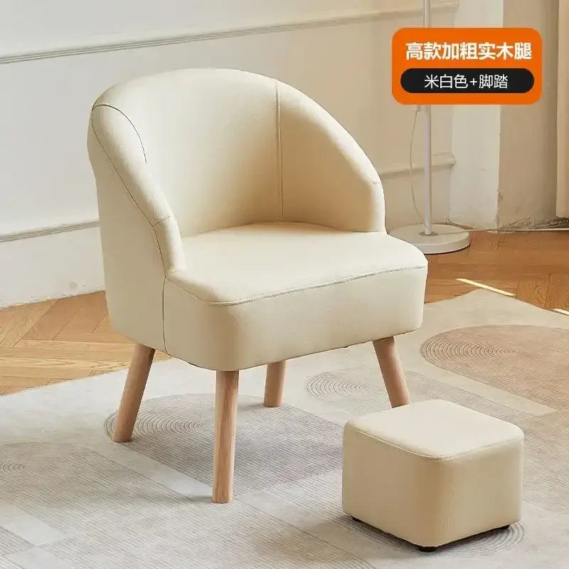 Cream-colored upholstered single sofa chair with thick rounded wooden legs and matching square footstool for living room