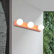 Modern orange and white vanity light fixture with three spherical bulbs for bedroom lighting