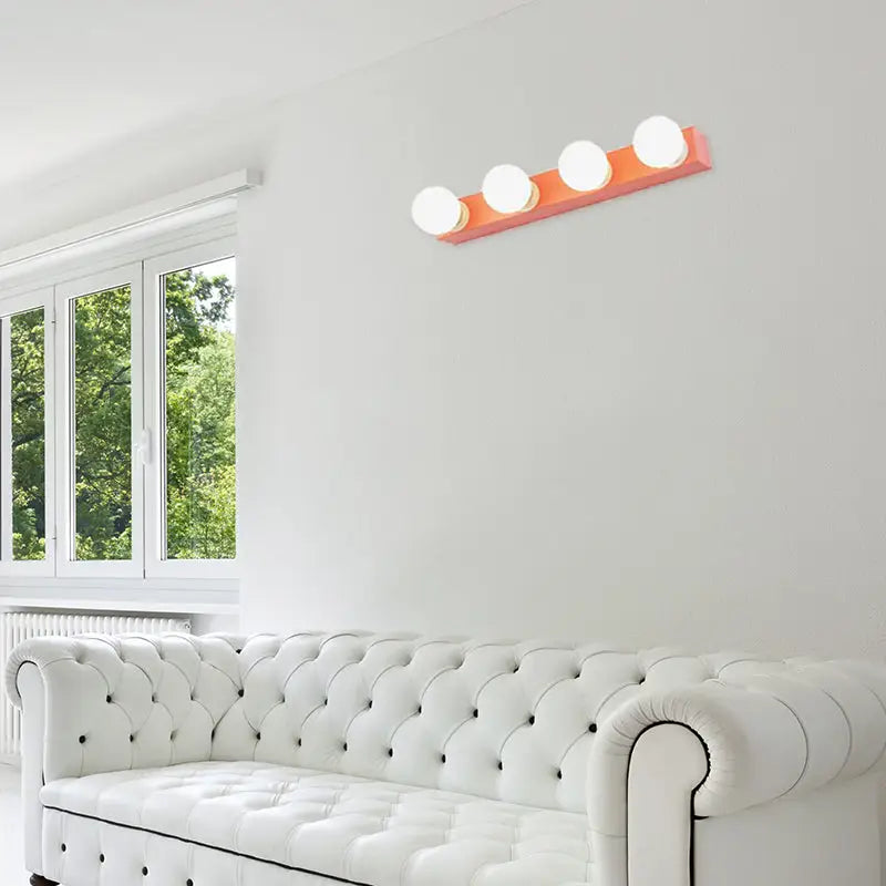 Modern orange vanity light fixture with four round white bulbs designed for bedroom use