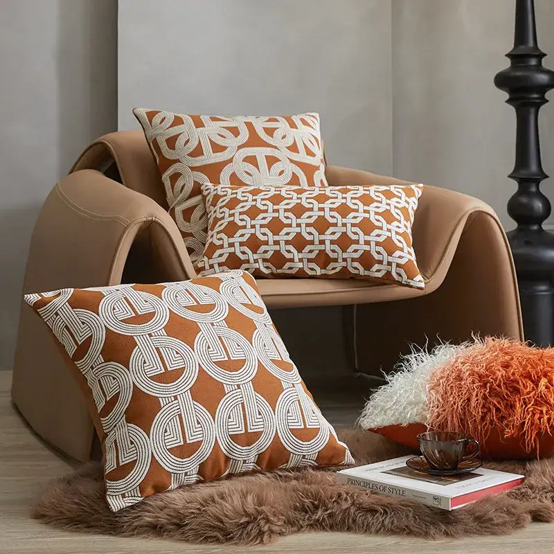 Modern orange and white jacquard crochet pillow covers with geometric patterns on a tan armchair and furry rug decorbites jacquard crochet pillow