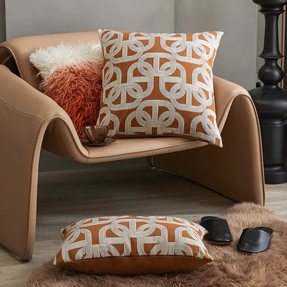 Modern orange and white jacquard crochet pillow cover with geometric pattern on tan leather armchair decorbites jacquard crochet pillow