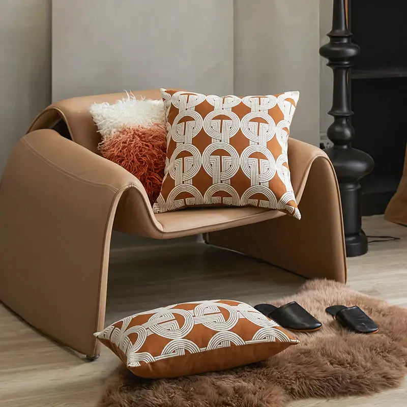 Tan leather armchair with curved modern design and decorbites jacquard crochet pillow covers for living room decor