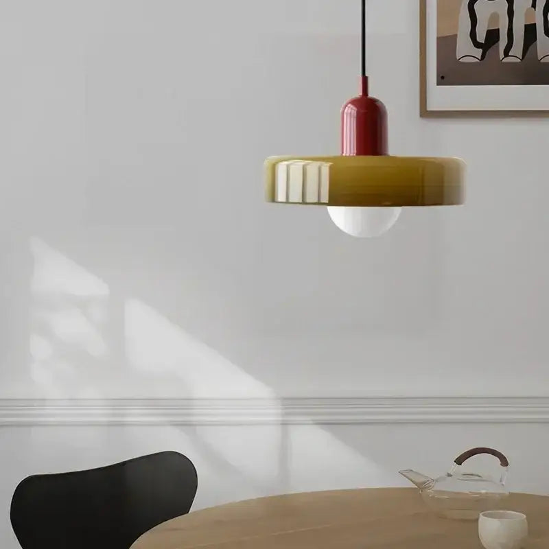 Modern glass led macaron ceiling chandelier with red and mustard-yellow glass led macaron shades above wooden table