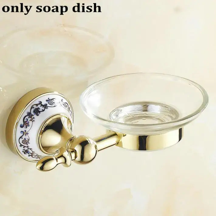 Modern ornate gold and white porcelain bath hardware set with gold-toned metal soap dish and blue floral backplate