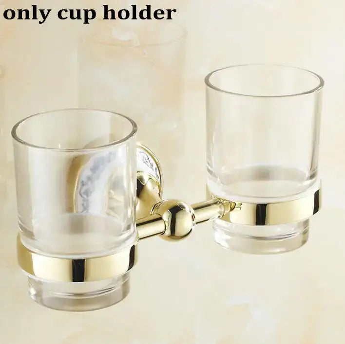 Modern ornate gold and white porcelain bath hardware set featuring a gold-toned double cup holder with glass cups