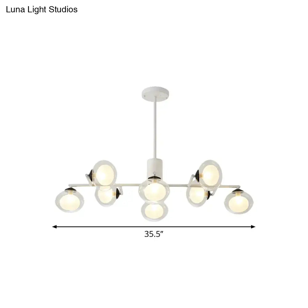Modern white chandelier with multiple spherical glass shades and sleek black white metal frame for island lighting