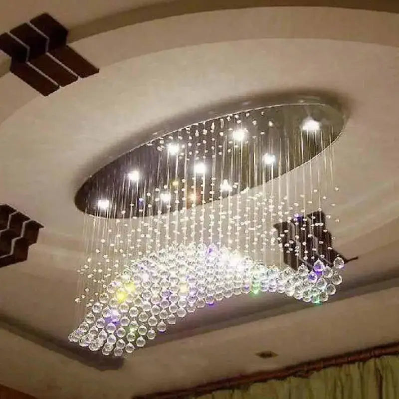 Modern oval crystal flush mount chandelier with cascading beads and metallic frame for dining room lighting